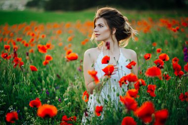 Gün batımında haşhaş tarlalarında güzel bir genç kız. 