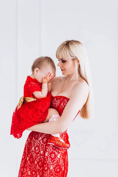 Szép, család, jó fotó anya és lánya piros ruhák a stúdióban. Anyák napja és leányai. — Stock Fotó