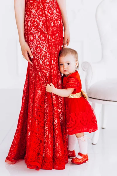 Ładne, rodzinne, dobre zdjęcie matki i córki w czerwone sukienki w studiu. Dzień matki i córki. — Zdjęcie stockowe