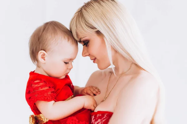Nice, family, good photo of mother and daughter in red dresses in the studio. Mothers Day and daughters. — Stock Photo, Image