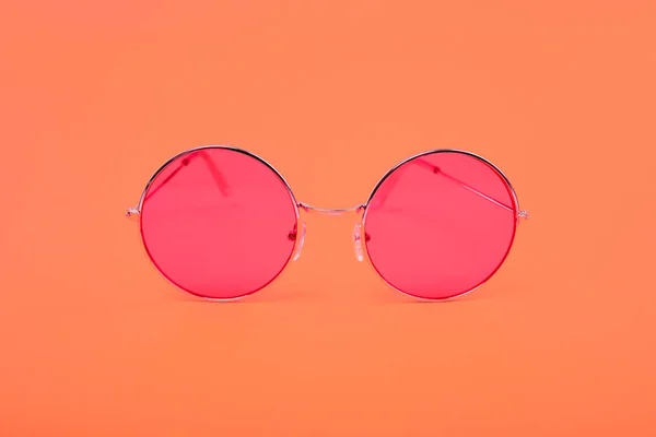 Bright red glasses on the background of the color Living Coral. — Stock Photo, Image