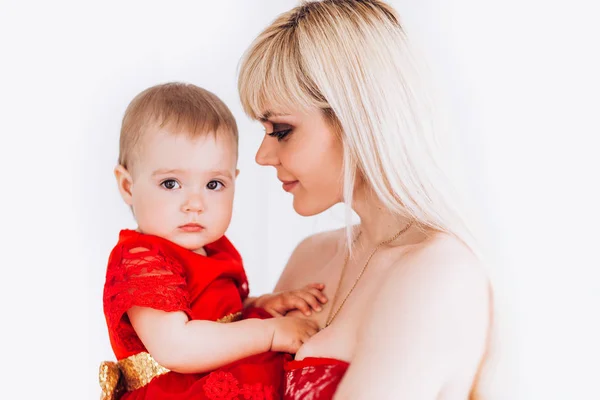 Trevlig, Familj, bra foto av mor och dotter i röda klänningar i studion. Mors dag och döttrar. Annonsera familjevärderingar och traditioner. — Stockfoto