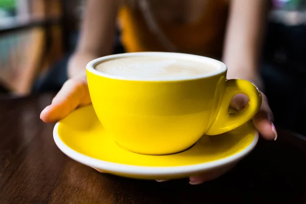 Yellow cup of aromatic coffee on a wooden table. — ストック写真