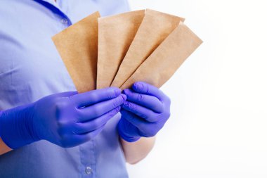Steril eldivenler giydirilen ellerde aletlerin sterilizasyonu için torbalar.