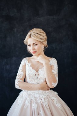 Profesyonel düğün makyajı ve saç modeli ile gelinin genç bir kız stüdyo portresi.