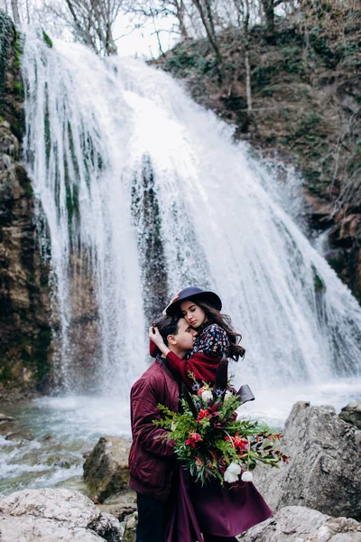 Una pareja amorosa, elegante y joven enamorada en el fondo de una cascada . —  Fotos de Stock