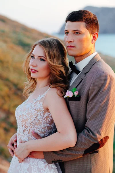 Feliz casal recém-casado. Bela noiva e noivo em um terno . — Fotografia de Stock