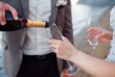 Mutlu yeni evli çift. Dağların bir arka plan üzerinde şampanya ile bir takım elbise güzel gelin ve damat.