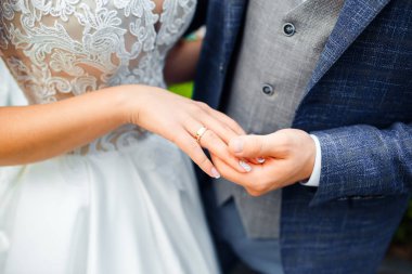 Gelin ve damadın elinde alyanslar.