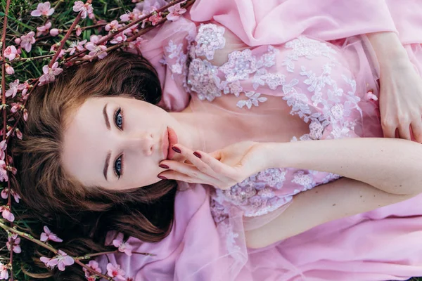 Pembe bir elbise ve makyaj şeftali pembe çiçekli bir bahçede genç kız.