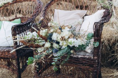 Bir boho hasır sandalyede gül ile Düğün asimetrik şık buket.