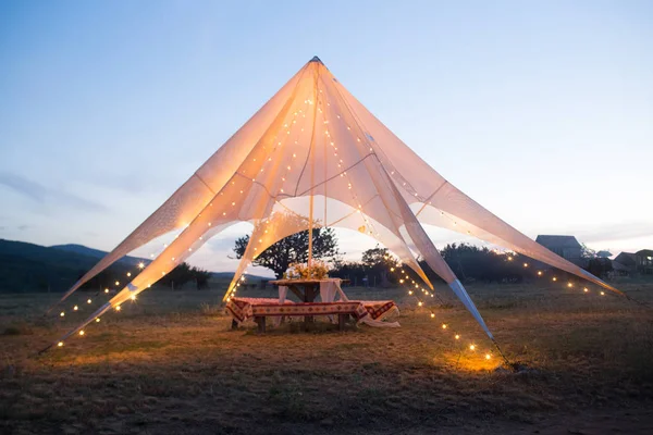 Бохо свадебная палатка на открытом воздухе для невесты и жениха с украшениями, цветами, огнями . — стоковое фото
