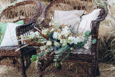 Bir boho hasır sandalyede gül ile Düğün asimetrik şık buket.