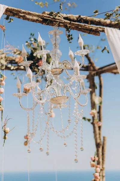 Fragment of a wedding arch for ceremony decorated with flowers and a chandelier. — Stock Photo, Image