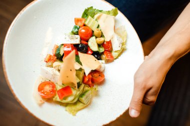 Bir tabak üzerinde orijinal bir porsiyon Yunan salatası. Domates, peynir, sebze.