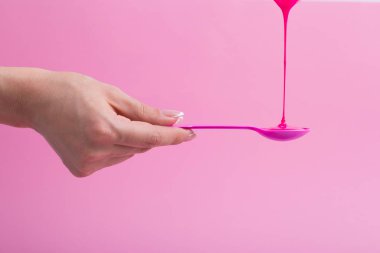 Pembe neon boya pembe bir kaşık üzerine akar.