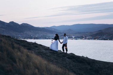 Boho tarzında aşık düğün çift. Asimetrik gül buketi.