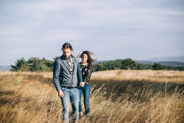 Kız arkadaşı ve erkek arkadaşı birlikte el ele tutuşur, tarlada yürürler..
