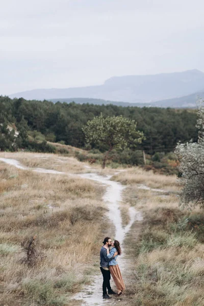Novio y novia corren en la hierba amarilla alta en el bosque . —  Fotos de Stock