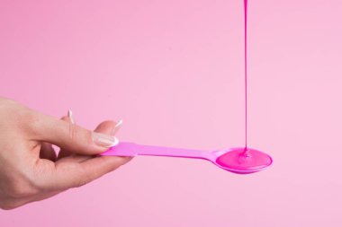 Pembe neon boya pembe bir kaşık üzerine akar.