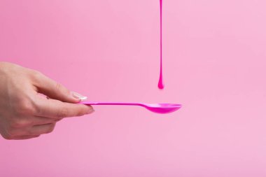 Pembe neon boya pembe bir kaşık üzerine akar.