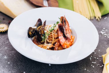 Beyaz bir tabak gri bir arka plan üzerinde kral karides ile Makarna.