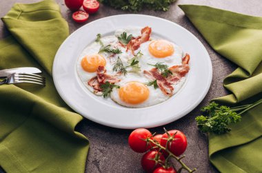 Beyaz bir tabak üzerinde pastırma ile tost yumurta.