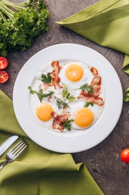 Beyaz bir tabak üzerinde pastırma ile tost yumurta.