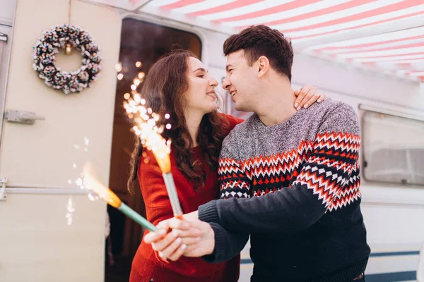 Amiga menina e namorado amigo celebrar o ano novo definir fogo para sparklers . — Fotografia de Stock