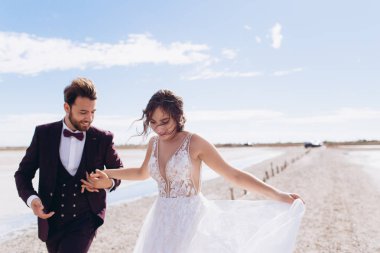 Mutlu gelin ve damat bir düğün günü çalıştırmak ve gülümseme. 