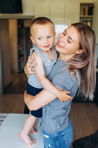 Mama przytula syna w kuchni. Rodzina w kuchni.. — Zdjęcie stockowe