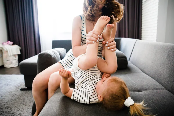 Mãe e filha abraçam-se em casa. Uma família feliz. Uma mãe a criar um filho. — Fotografia de Stock
