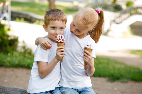 Children eat ice cream in the park.