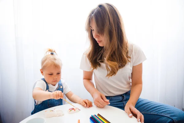 Anya és lánya együtt festenek. A gyermek az anyjával rajzol.. — Stock Fotó