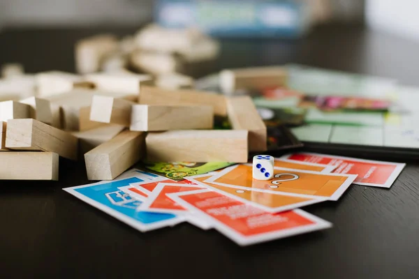 Bunte Spielfiguren und Karten mit Würfeln an Bord — Stockfoto