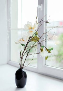 yaz çiçekleri siyah vazoda pencere eşiğinde güneş ışığında