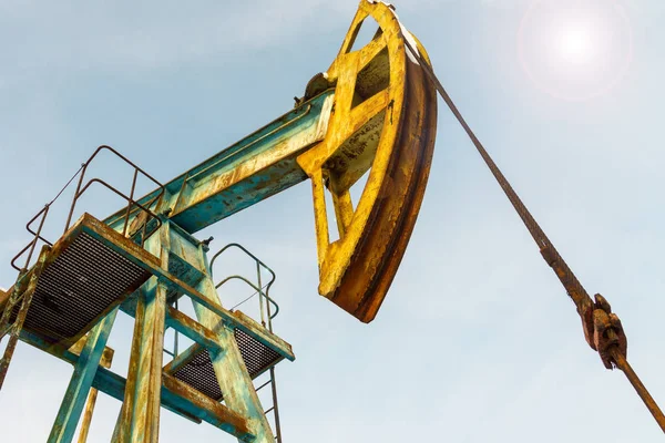 Minería y canteras. Instalaciones para la extracción de petróleo de las entrañas de la Tierra. Pumpjack es la unidad de tierra para una bomba de pistón alternativo en un pozo de aceite . — Foto de Stock