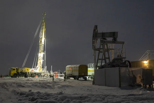 Oil rig and brightly lit industrial site at night. Blur photo effect. Extraction of oil. — Stock Photo, Image