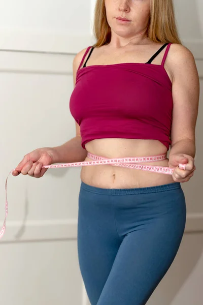 Primer plano de la mujer pellizcando grasa del vientre. Joven mujer delgada en pantalones cortos azules pellizcando su abdomen. Concepto de dieta y pérdida de peso . — Foto de Stock