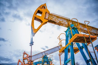 Petrol ve gaz endüstrisi. Bir günbatımı gökyüzü arka plan üzerinde siluet yağ pompaları. Tonda. Petrol endüstrisi ekipmanları.