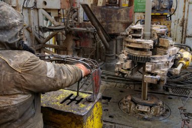 Offshore petrol kuyusu işçisi kuyu başındaki petrol kuyusunda delik açmak için alet ve ekipman hazırlayın. Sondaj borusu bağlantısı kuruyorum. Tribünlerin arasından matkap borusu bağlantısı için bir görünüm.