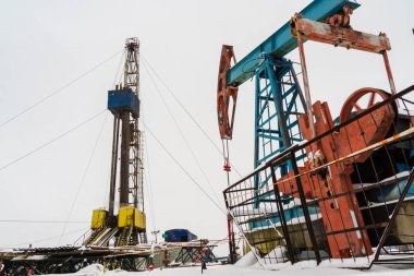 Petrol ve Gaz Sondaj Kulesi dramatik cloudscape ile karatatlı. Petrol ve gaz endüstrisinde petrol platformunda petrol sondaj kulesi işletmesi. Kara petrol sondaj kulesi mavi gökyüzü