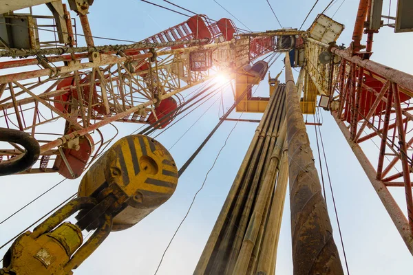 Plataforma de perforación de petróleo y gas postre en tierra con un paisaje nublado dramático. Operación de perforación de petróleo en la plataforma petrolera en la industria del petróleo y el gas. Tierra petróleo perforación plataforma cielo azul — Foto de Stock