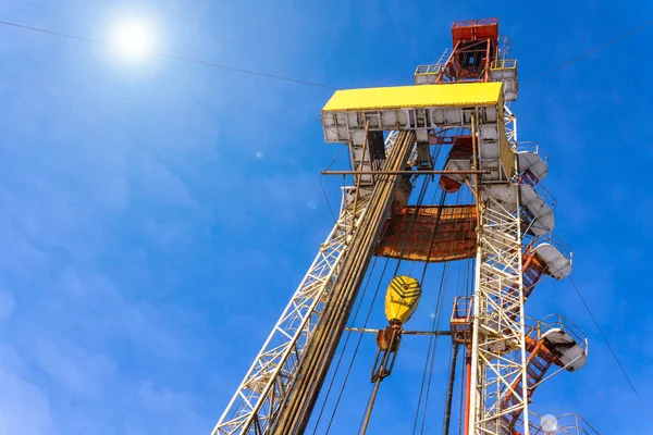 Oil and Gas Drilling Rig onshore dessert with dramatic cloudscape. Oil drilling rig operation on the oil platform in oil and gas industry. Land drilling rig blue sky.