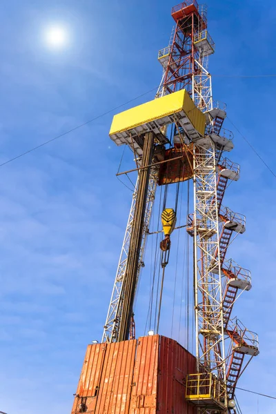 Oil and Gas Drilling Rig onshore dessert with dramatic cloudscape. Oil drilling rig operation on the oil platform in oil and gas industry. Land drilling rig blue sky.