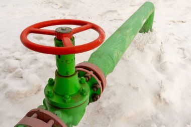 Kapak armatürü olan bir kuyu başının yatay görünümü. Petrol ve gaz endüstrisi kavramı. Arka planda sallanan yağ vanası. Kontrol gazları için offshore petrol ve gaz saha servisi operatörü açık vana.