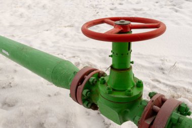Kapak armatürü olan bir kuyu başının yatay görünümü. Petrol ve gaz endüstrisi kavramı. Arka planda sallanan yağ vanası. Kontrol gazları için offshore petrol ve gaz saha servisi operatörü açık vana.