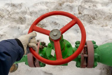 Kapak armatürü olan bir kuyu başının yatay görünümü. Petrol ve gaz endüstrisi kavramı. Arka planda sallanan yağ vanası. Kontrol gazları için offshore petrol ve gaz saha servisi operatörü açık vana.