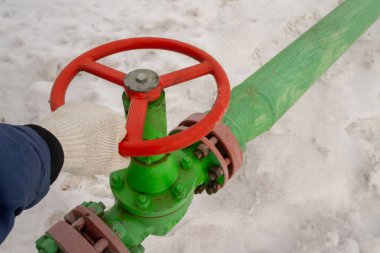 Kapak armatürü olan bir kuyu başının yatay görünümü. Petrol ve gaz endüstrisi kavramı. Arka planda sallanan yağ vanası. Kontrol gazları için offshore petrol ve gaz saha servisi operatörü açık vana.