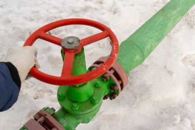 Kapak armatürü olan bir kuyu başının yatay görünümü. Petrol ve gaz endüstrisi kavramı. Arka planda sallanan yağ vanası. Kontrol gazları için offshore petrol ve gaz saha servisi operatörü açık vana.